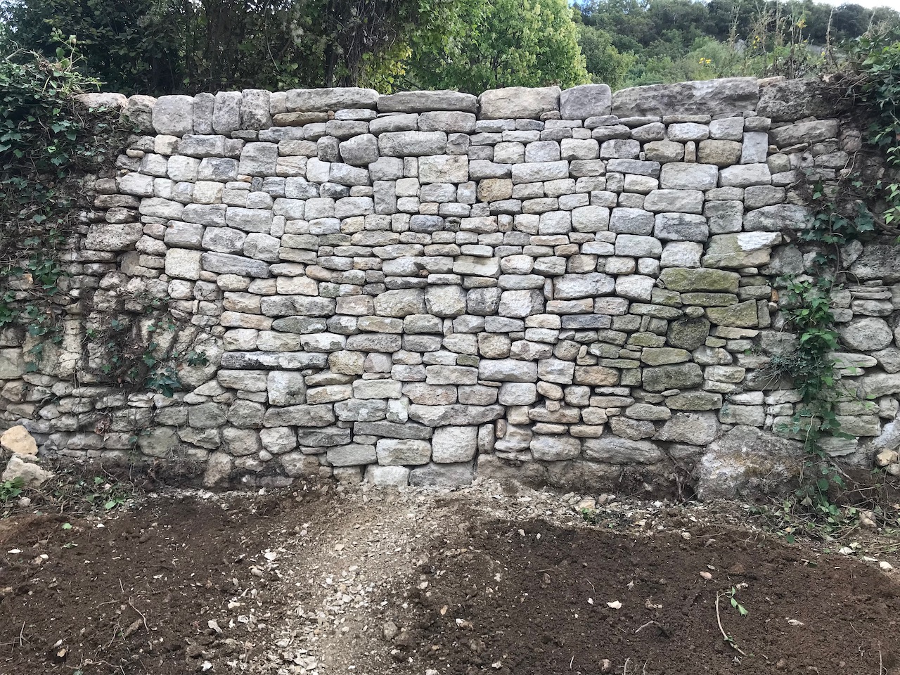 Restauration d'une brèche dans un mur de soutènement en pierre sèche